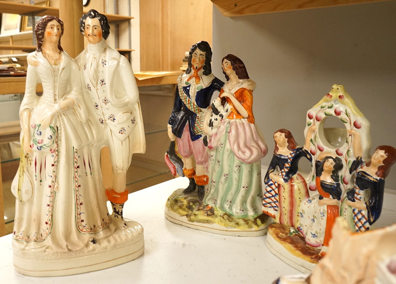 A collection of Staffordshire figures, mostly flatback to include a pocket watch holder, largest 37cm high